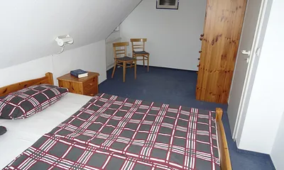 Schlafzimmer mit Doppelbett und Platz für Babybett