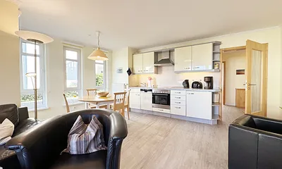 Wohnzimmer mit TV und Blick zur Küchenzeile