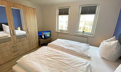 Schlafzimmer mit Boxspringbett (1,80 m x 2,00 m), Kleiderschrank, Nachttische, Sideboard sowie ein zweiter Smart-TV