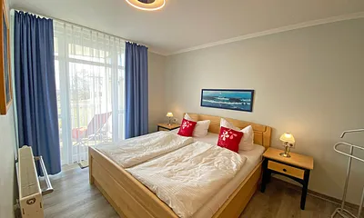 Schlafzimmer mit Doppelbett (1,80 m x 2,00 m), verstellbare Lattenroste, Kleiderschrank, Nachttischkonsolen und Verdunklungsvorhänge