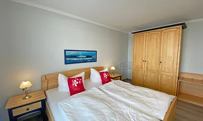 Schlafzimmer mit Doppelbett (1,80 m x 2,00 m), verstellbare Lattenroste, Kleiderschrank, Nachttischkonsolen und Verdunklungsvorhänge