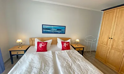 Schlafzimmer mit Doppelbett (1,80 m x 2,00 m), verstellbare Lattenroste, Kleiderschrank, Nachttischkonsolen und Verdunklungsvorhänge