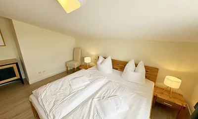 Schlafzimmer mit Doppelbett, Kleiderschrank, Nachttischkonsolen