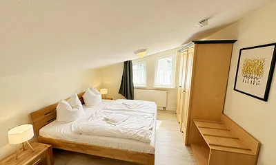 Schlafzimmer mit Doppelbett, Kleiderschrank, Nachttischkonsolen