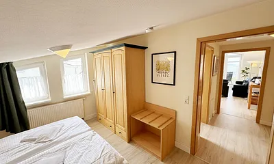 Schlafzimmer mit Doppelbett, Kleiderschrank, Nachttischkonsolen