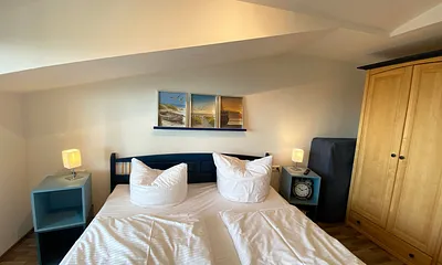 Schlafzimmer mit Doppelbett, Kleiderschrank, Nachttischkonsolen