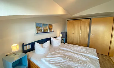 Schlafzimmer mit Doppelbett, Kleiderschrank, Nachttischkonsolen