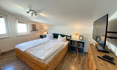 Schlafzimmer mit Doppelbett, Kleiderschrank, Nachttischkonsolen