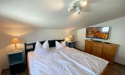 Schlafzimmer mit Doppelbett, Kleiderschrank, Nachttischkonsolen