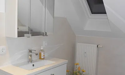 Ein geräumiges Badezimmer mit modernem Waschtisch runden das Bild dieser gemütlichen Wohnung ab. 