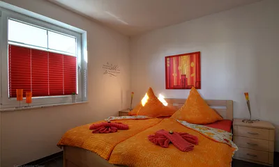 Schlafzimmer mit Doppelbett und großem Kleiderschrank. Die Erstausstattung mit Bettwäsche ist inklusive.