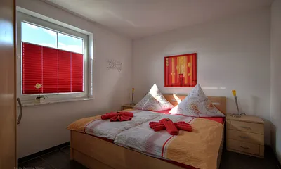 Schlafzimmer mit Doppelbett und großem Kleiderschrank. Die Erstausstattung mit Bettwäsche ist inklusive. 