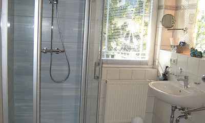Blick in eines der beiden Bäder. Beide mit Fenster, nahezu ebenerdiger neuer Dusche, WC & Kosmetikspiegel, dieses hier zusätzlich mit Fön, das andere mit Münzwaschmaschine.