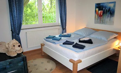 Blick in eines der beiden Schlafzimmer, beide mit Doppelbett (Laminat, getrennte Matratzen, Insektenschutzgitter )