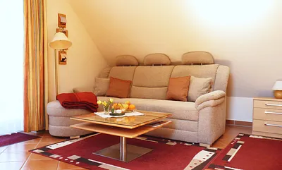 Couchecke mit Tisch und Standleuchte (ggf. ausklappbar zur Doppelbettliege bei Aufbettung) im Wohnbereich für den gemütlichen Teil des Abends oder bei "Schietwetter"