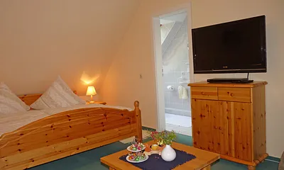 Sideboard mit Wand-Flachbildschirm (90° schwnekbar) und Eingang zum angrenzenden Duschbad