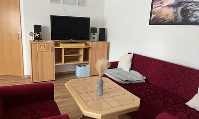 Das Wohnzimmer mit Essbereich ist mit einem großen Fernseher und einer CD-Anlage ausgestattet.