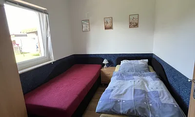 Im zweiten Schlafzimmer befinden sich zwei separate Liegen und ein Kleiderschrank.