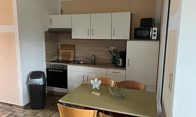 Das ist die Küche mit Wasserkocher, Kaffeemaschine, Toaster ,Kühlschrank mit kleinem Gefrierfach, Herd mit Backofen