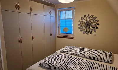 Schlafzimmer 1 im 1. OG mit Doppelbett, angrenzendem Duschbad und TV