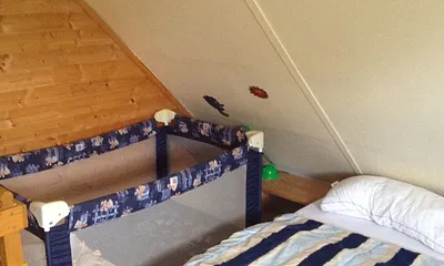 Im oberen Schlafraum bieten wir neben einem Doppelbett und einem separaten Bett ein Reisebett für Kleinkinder.