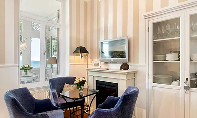 Am Kamin (elektr.) ist die Fernsehecke mit großem Flachbild-TV eingerichtet. Auch von hier sehen Sie das Meer.