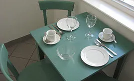 Der kleine Esstisch steht in der abgeteilten Küche. Sie finden dort  alles nötige, um Speisen fast wie zuhause zubereiten zu können.