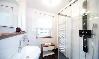 Das Bad mit Dusche, Waschtisch, WC und Sichtschutzplissee am Fenster. Des weiteren hat die Fewo ein zusätzliches Gäste-WC.