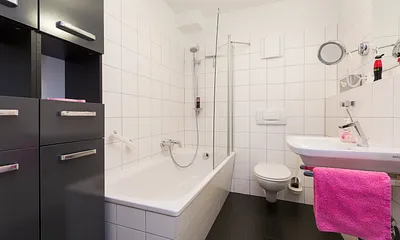 Das Bad hat eine Badewanne mit integrierter Dusche und WC.
