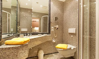 Hier sehen Sie das luxuriöse Natursteinbad mit großem Waschtisch. 