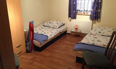 Schlafraum mit 2 Einzelbetten sowie Kinderreisebett
