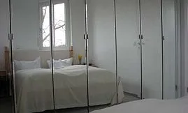 Verspiegelt: Schlafzimmer mit Doppelbett.