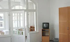 Die 1 Zi.-FW hat einen separaten Wintergarten mit Sitzecke. Im Hauptraum gibt es auch einen Schreibtisch.