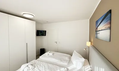 Schlafzimmer mit Kleiderschrank und TV