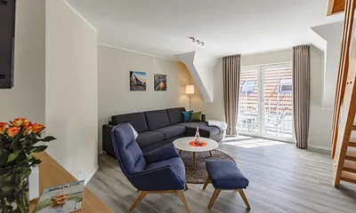 Wohnzimmer mit Couch und Sessel