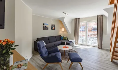 Wohnzimmer mit Couch und Sessel