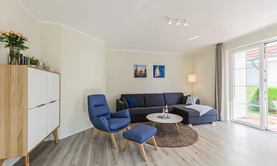 Wohnzimmer mit Couch und Sessel