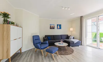 Wohnzimmer mit Couch und Sessel
