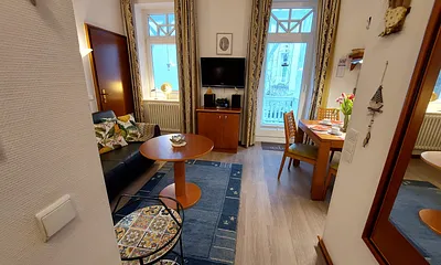 Blick ins Wohnzimmer mit angrenzendem Essbereich vom Apartmenteingang