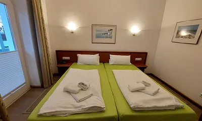 Schlafzimmer-1 mit 2 Betten in den Maßen 1,00 m x 2,00 m und separatem Zugang zum Badezimmer-1, Ankleidezimmer und Balkon