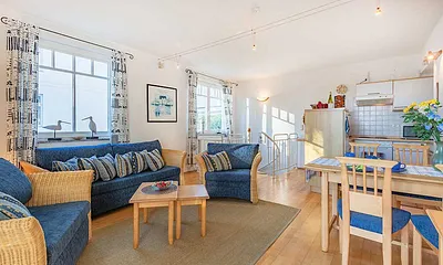 Sitzbereich und Esstisch und Küche im Hintergrund