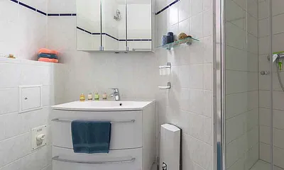 Badezimmer mit Toilette, Waschbecken und Spiegelschrank ...