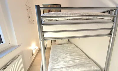 kleines Kinderzimmer mit Doppelstockbett und Schrank