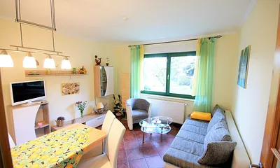 Wohnzimmer mit Schlafcouch und Essecke