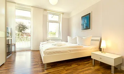 Hier der Blick in das große Schlafzimmer mit TV, Kleiderschrank  und Austritt zum Balkon.