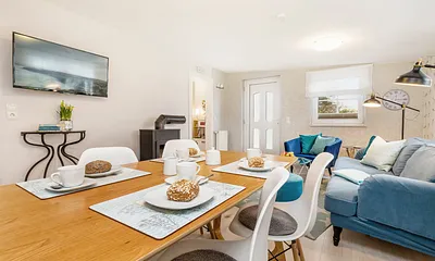 Blick durch das Wohnzimmer mit Flat-TV und Kaminofen. WLAN ist kostenfrei.