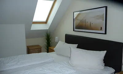 1 Schlafzimmer mit Doppelbett und Bettwäsche