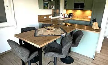 Esstisch mit Küchenzeile im Hintergrund