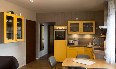 Ansicht Küchenzeile mit Spülmaschine, Backofen und Essbereich im Wohnzimmer