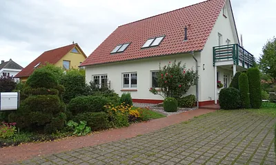 Wohnhaus mit Gästebalkon und Parkplatz